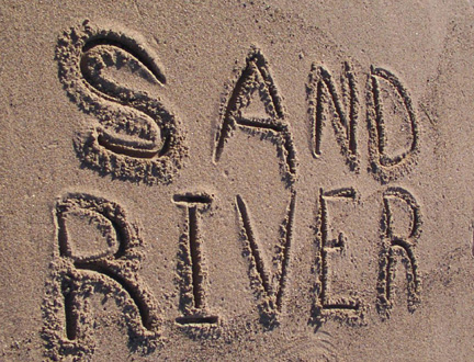 Words "Sand River" scratched into the beach sand